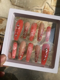 a person holding a box of pink nail polish