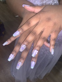 a woman's hands with purple and lavender nails